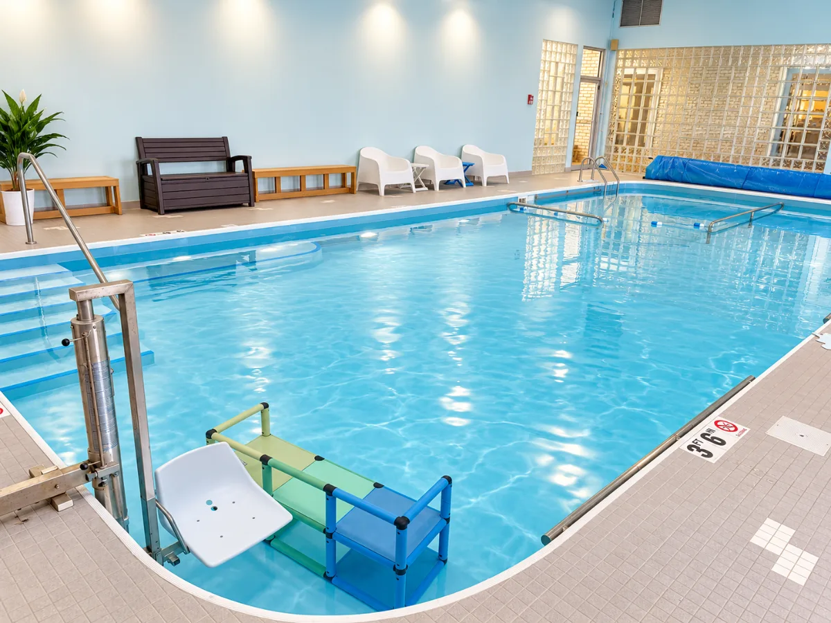 The warm-water pool at Anchor Wellness Studio with a pool lift, entry steps and seating along the wall